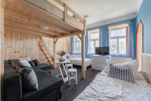 a living room with a loft bed and a couch at Penzion Polubný in Kořenov