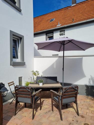 een tafel en stoelen met een parasol op een patio bij Apartement “Heckeresje“ in Pfungstadt