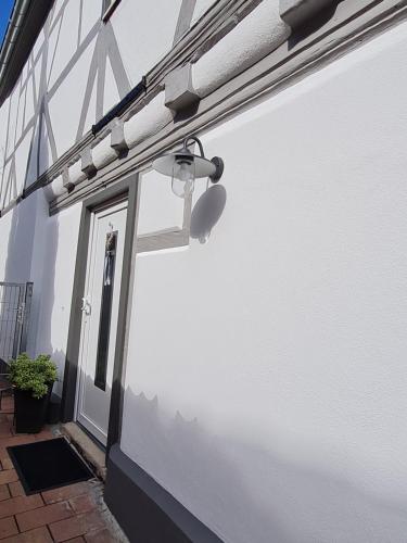 een witte muur met een deur en een licht bij Apartement “Heckeresje“ in Pfungstadt