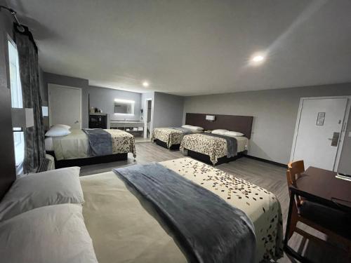a hotel room with three beds in a room at Ridge Motel in Breckenridge