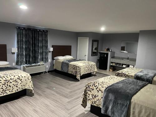 a hotel room with three beds in a room at Ridge Motel in Breckenridge