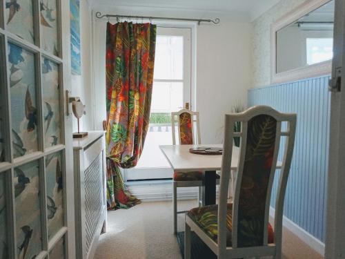 a dining room with a table and a window at Beachfront Studio Apartment in Felixstowe