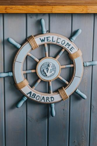 a welcome aboard sign on a wooden wall at Ragaciema Skadiņi in Ragaciems