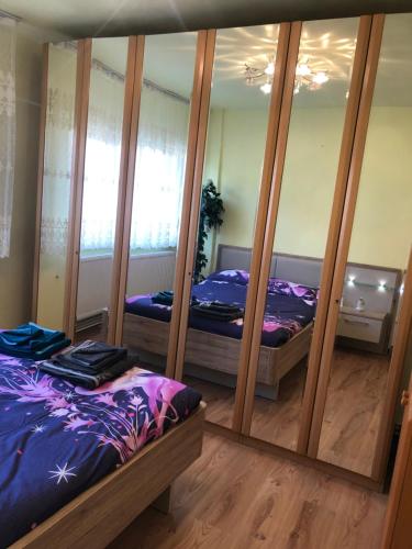 a bedroom with two beds and a mirror at La SYMO apartament STRAJA Lupeni in Lupeni