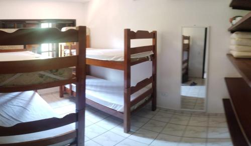 a room with two bunk beds and a mirror at Condômino do Barão in São Sebastião