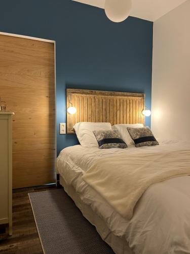 um quarto com uma grande cama branca e 2 almofadas em Appartement 2 personnes : LES CANAUX em Amiens