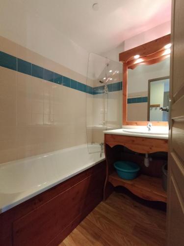 une salle de bain avec une baignoire, un lavabo et un miroir dans l'établissement Appartement Le Sorbier à Chamrousse 3 pièces 6 personnes aux pieds des pistes, à Chamrousse