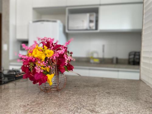 a vase of flowers sitting on a counter in a kitchen at Solar Porto Rico in Porto De Galinhas