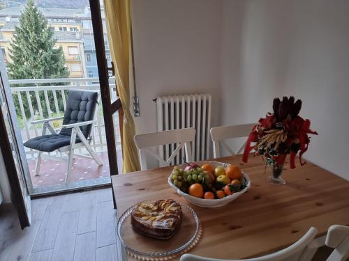 a wooden table with a bowl of fruit on it at Mary House in Sondrio