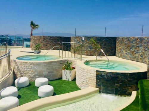 a pool with two hot tubs in a building at Luxury Ocean Spa Plaza Private Large 1 bed apartment in Gibraltar
