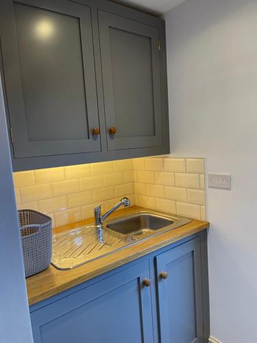 a kitchen counter with a sink and a cabinet at Charming, cosy waterside retreat in Gimingham, North Norfolk in Gimingham