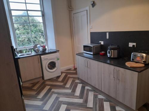 a kitchen with a sink and a washing machine at Traditional west end Glasgow in Glasgow