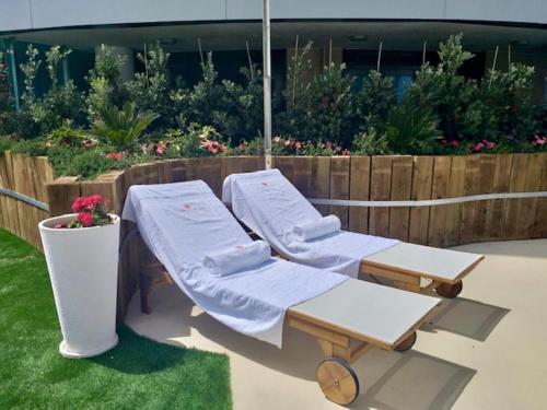 two lounge chairs and a table in a yard at Luxury Ocean Spa Plaza Private Large 1 bed apartment in Gibraltar