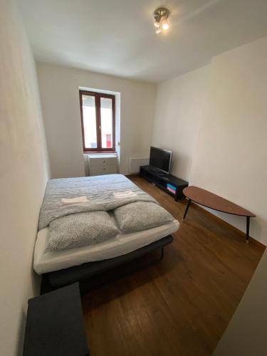 um quarto com uma cama e uma secretária. em Vesoul appartement atypique centre ville. em Vesoul