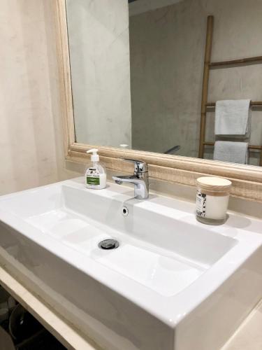 un lavabo blanc dans une salle de bain avec un miroir dans l'établissement Charming and modernly designed 2 bedroom - Old Town, à Antibes