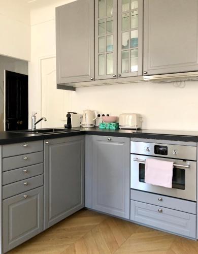 une cuisine avec des armoires blanches, un évier et une cuisinière dans l'établissement Charming and modernly designed 2 bedroom - Old Town, à Antibes