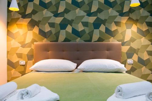 un letto con due cuscini e una parete colorata di WANDERLUST NAPLES a place to stay a Napoli