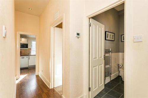 um corredor com uma porta que conduz a uma cozinha em Aberdeen haven in Aberdeen city center em Aberdeen
