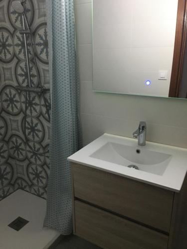 baño con lavabo y cortina de ducha en Roche Pinos Verdes, en Roche
