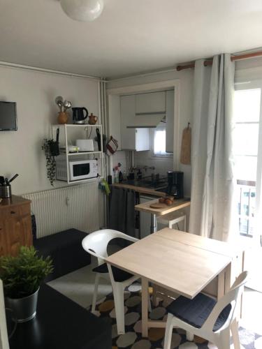 une cuisine avec une table et des chaises dans une pièce dans l'établissement Studio rénové résidence privé proche de toutes commodités et loisirs, Place parking inclus, à La Bourboule