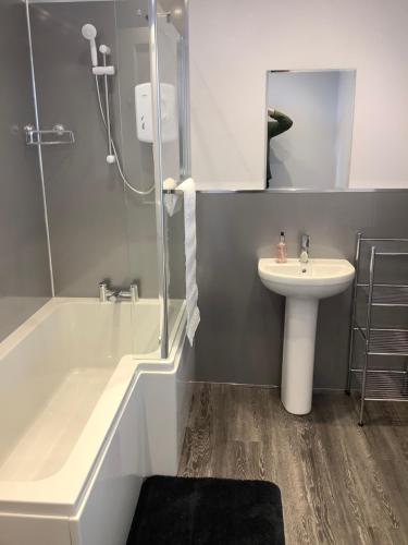 a bathroom with a tub and a sink and a shower at Harbour View in Wick