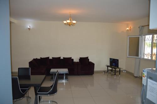 a living room with a couch and a table and chairs at Résidence Rosalie in Yaoundé