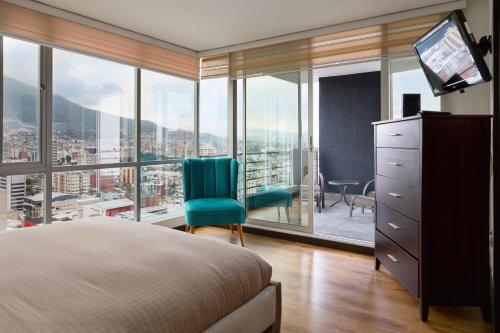a bedroom with a bed and a large window at Olympus Apartments in Quito