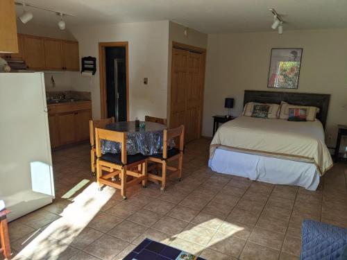 a bedroom with a bed and a table and a kitchen at Studio apartment 15 minute walk to plaza in Santa Fe