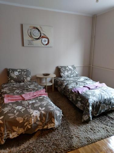 a bedroom with two beds and a table in it at Ino 99 in Užice