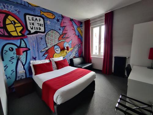 a bedroom with a bed with a painting on the wall at The Originals Boutique, Hôtel de l'Univers, Montluçon in Montluçon