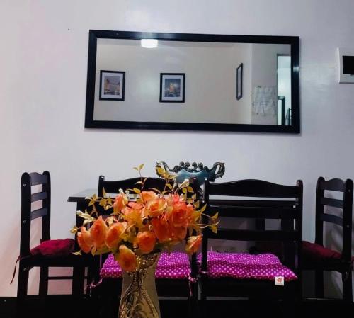 a dining room table with a vase with flowers on it at Estien’s cozy condo to stay with kitchen in Manila