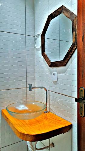 a bathroom with a sink on a wooden counter at Japaratinga Suites in Japaratinga