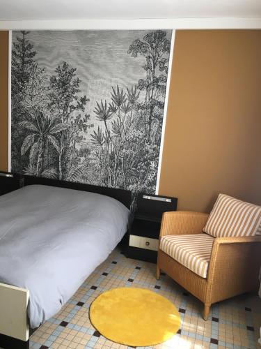 une chambre avec un lit, un canapé et une chaise dans l'établissement Charmant appartement sur cour, Le Cerisier, à Bagnères-de-Bigorre