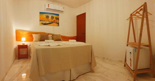 a bedroom with a bed with a table in it at Japaratinga Suites in Japaratinga