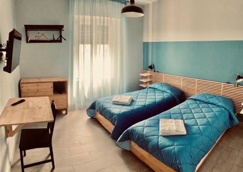 a bedroom with two beds and a table and a desk at Il Covo degli Arditi B&B in Potenza