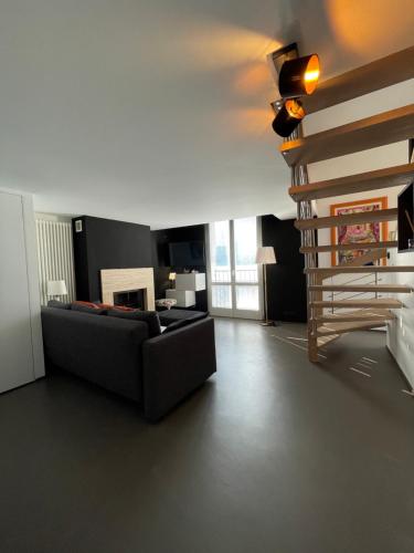 ein Wohnzimmer mit einem Sofa und einer Treppe in der Unterkunft l'angolo sul porto in Brenzone sul Garda