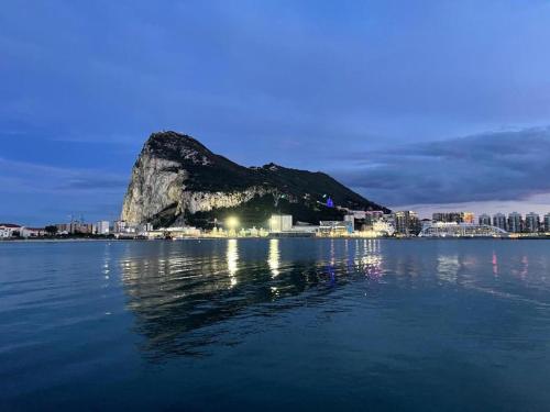 a view of a mountain in the water at night at Luxury Ocean Spa Plaza Private Large 1 bed apartment in Gibraltar
