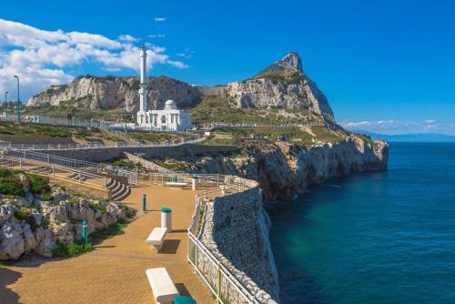 a view of the ocean with a lighthouse on a mountain at Luxury Ocean Spa Plaza Private Large 1 bed apartment in Gibraltar