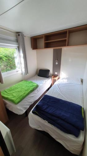 deux lits dans une chambre avec une fenêtre dans l'établissement 3 chambres mimizan gastes biscarrosse camping siblu, à Gastes