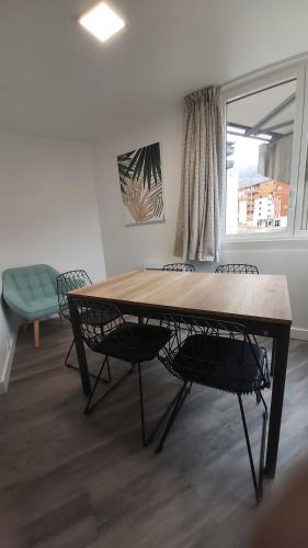 une salle à manger avec une table et des chaises et une fenêtre dans l'établissement Menuires - Appart moderne 5 pers+Parking couvert, aux Menuires