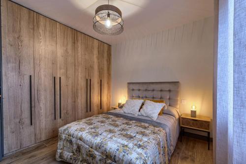 1 dormitorio con 1 cama grande y armarios de madera en Apartamento de Diseño elegante by the urban hosts, en Bilbao