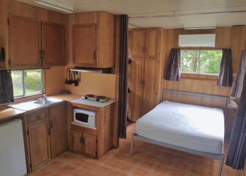a small room with a bed and a kitchen at Warburton Holiday Park in Warburton