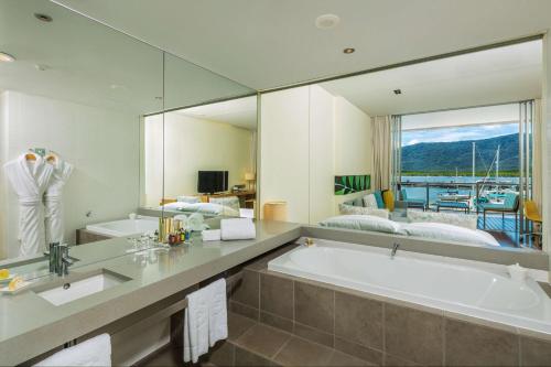 凯恩斯Shangri-La The Marina, Cairns的一间带大浴缸和大镜子的浴室