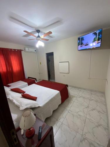 1 dormitorio con 2 camas y TV de pantalla plana en Departamento Urquiza en Salta