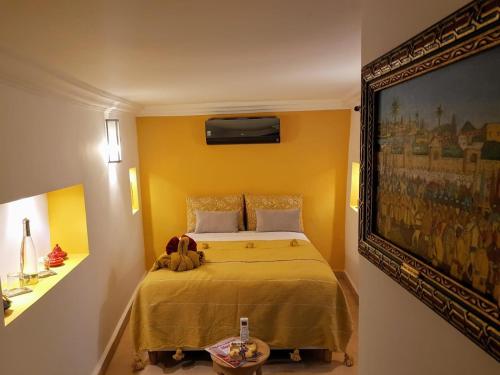 1 dormitorio con 1 cama y una pintura en la pared en Riad BILKIS, en Marrakech