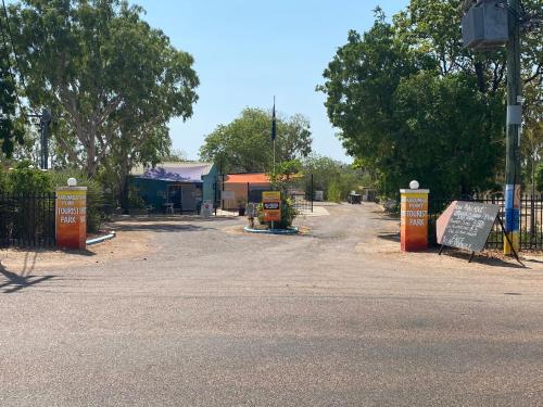 a dirt road with a fence and a sign at Karumba Point Holiday & Tourist Park in Karumba