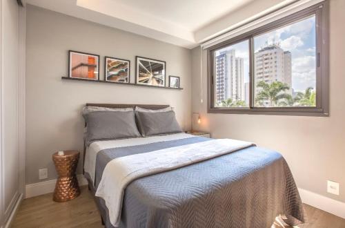 a bedroom with a bed and a large window at Aconchegante e Sofisticado in São Paulo