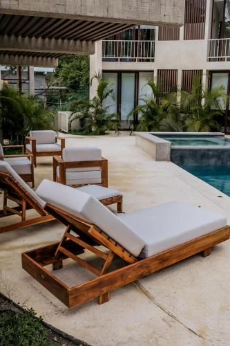 a bed and lounge chairs next to a pool at La Bohème Sayulita in Sayulita