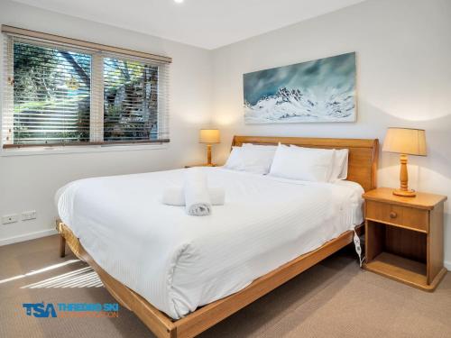 Un dormitorio con una cama grande y una ventana en Snowman 2 en Thredbo