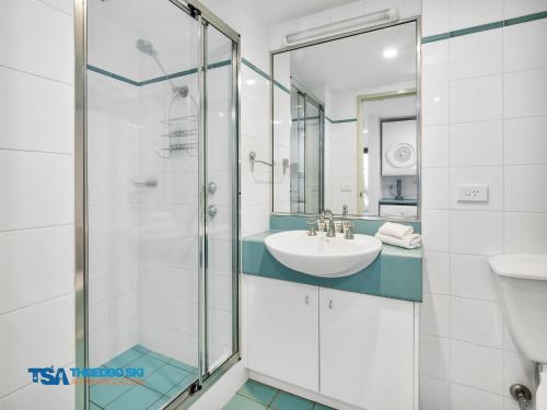 a bathroom with a glass shower and a sink at Snowman 2 in Thredbo
